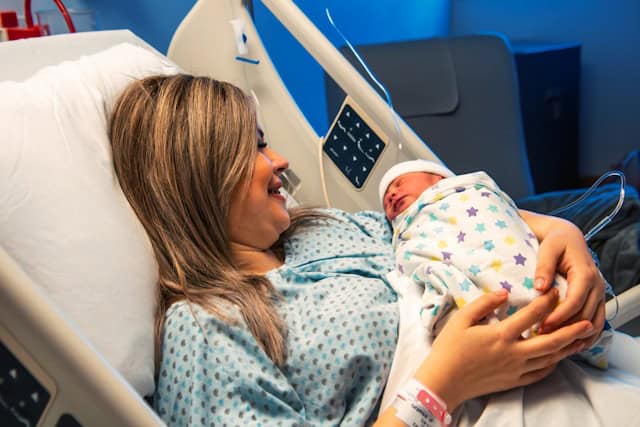 Mother holding newborn baby in hospital after childbirth.